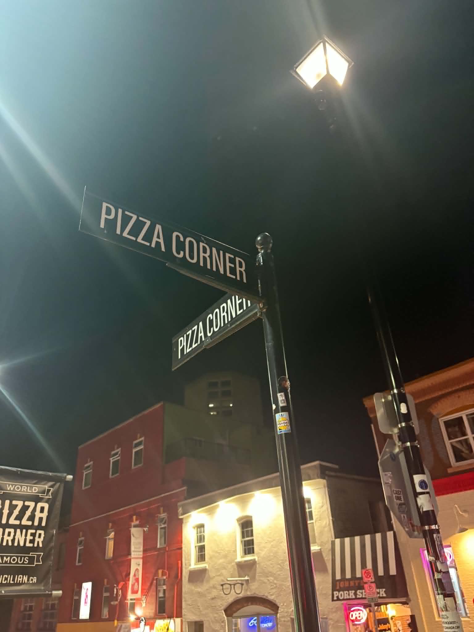 Pizza Corner street sign at night